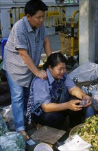 THAILAND, North, Chiang Mai, Wholesale Food Market.  Female vendor seated at vegetable stall having
