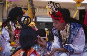 THAILAND, North, Chiang Mai, "Chinese New Year.  Young woman applying make-up to another, both in