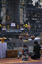 THAILAND, North, Chiang Mai, Wat Chettawan on Tha Phae Road.  Young woman and girl kneeling with