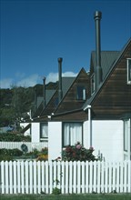 NEW ZEALAND, South Island, Akaroa, Line of houses with narrow chimneys and white painted picket