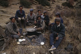 CHINA, Tibet, Terdrom, "Group of labourers having lunch, sitting on ground around cooking pot
