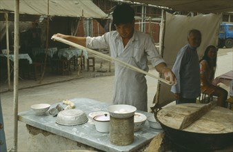 CHINA,  Luoyang,  Man making noodles at street stall.