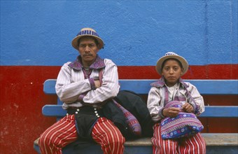 GUATEMALA, Todos Santos Cuchumatan, "Father and Son dressed identically, sitting on a blue bench