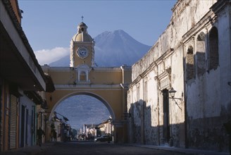 GUATEMALA, Antigua, "Arco de Santa Catarina. Yellow painted archway with clock tower and people