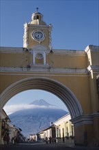 GUATEMALA, Antigua, "Arco de Santa Catarina. Yellow painted archway with clock tower and people
