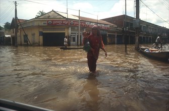 CLIMATE, Weather, Flood, Woman holding young child whilst wading through flooded street