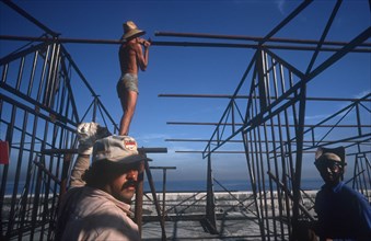 CUBA, Havana, Construction workers erecting metal framework for stalls during the Carnival on the
