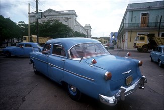 CUBA, Matanzas, Old blue American cars being driven in the street