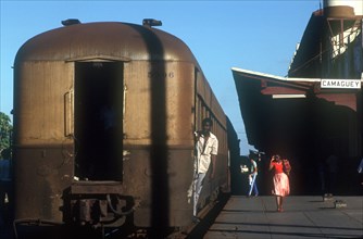 CUBA, Camaguey, Railway carriages alongside the platform of Camaguey station with a man holding