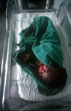CUBA, Havana, Newborn baby wrapped in green towel in maternity hospital