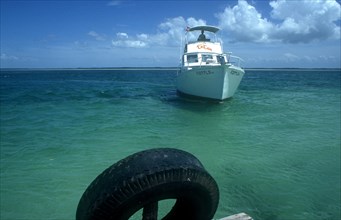 CUBA, Ciego de Avila, Cayo Guillermo, Deep sea fishing boat approaching jetty in clear light blue