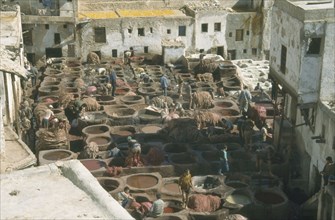 MOROCCO, Atlas Mountains, Fes, Chouras tanneries. View over workers and large dye vats.