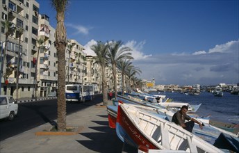 EGYPT, Alexandria, View along the esplanade lined with palms and fishing boats pulled ashore.