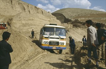 CHINA, Shaanxi , Bus stuck in earth along the main road with people standing by the sides of the