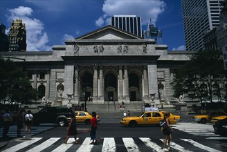 USA, New York , New York City, New York Public Library with pedestrian crossing and yellow cabs in