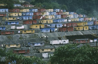 SWAZILAND, General, "Red , yellow and blue painted housing built on a concreted hillside"