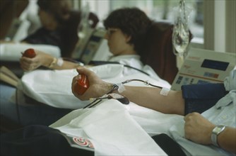 HEALTH, Blood , Men and women donors giving blood with mans arm in the foreground