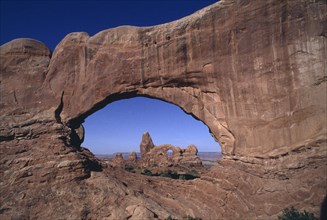 USA, Utah, Arches National Park, View through natural rock archway toward rock formations