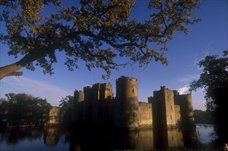 ENGLAND, East Sussex, Bodiam, The Castle and moat seen through trees