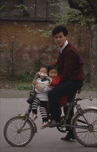CHINA, Sichuan, Chengdu, Man and two small children on a bicycle