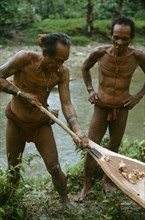 INDONESIA, Sumatra, Siberut Island, Two local men building a wooden canoe