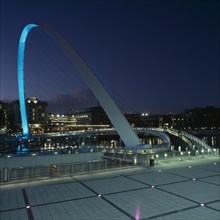 ENGLAND, Tyne and wear, Gateshead, The new Millennium Footbridge illuminated at night.