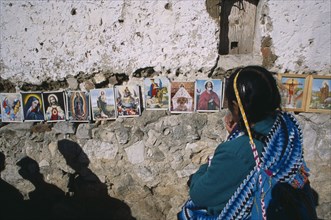MEXICO, Chiapas, San Cristobal de Las Casas, Woman in front of coloured pictures of the lives of