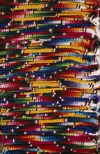 MEXICO, Chiapas, San Cristobal de Las Caras, Close view of layered pile of multicoloured textiles.