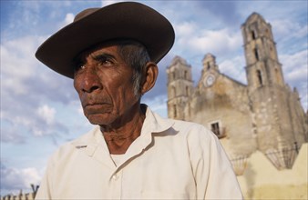 MEXICO, Yucatan, Hoctun, "Elderly man in hat, head and shoulders portrait with church building part