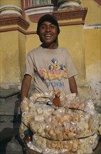 MEXICO, Chiapas, San Cristobal de Las Casas, Street food vendor with basket piled with bags of