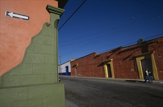 MEXICO, Oaxaca, Oxaca City, Corner of green and orange painted building with white arrow on black