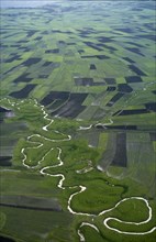 ETHIOPIA, South West, Landscape, Aerial view over river meandering through agricultural land.