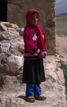 IRAN, Zagros Mountains, Qashqai nomad young girl in red and white spotted headscarf.  Standing with