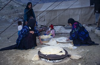 IRAN, Zagros Mountains, Qashqai nomad family making bread at a camp in the Zagros Mountains.