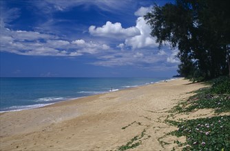 THAILAND, Phuket , Mai Khao Beach, View along quiet sandy beach fringed with trees and vegetation