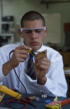EDUCATION, Secondary School, Science, Schoolboy in electronics class wearing protective glasses