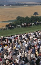 20026915 ENGLAND West Sussex Goodwood Crowds and line of bookmakers watching horse race at Goodwood racecourse on the South Downs.