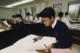 EDUCATION, Secondary, Classroom, Asian teen boy using electronic calculator in class
