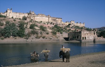 INDIA, Rajasthan, Amber , "Hilltop Palace dating from 1592, seen over water with three elephants