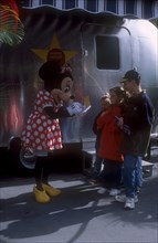 USA, Florida, Orlando, Walt Disney World. Minnie Mouse signing autographs for three children