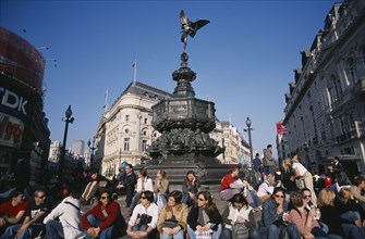 ENGLAND, London, Piccadilly Circus with mixed young crowd congregated around base of Alfred