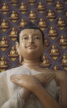 MALAYSIA, Penang, Georgetown, Wat Chayamangkalaram.  Detail of Buddha figure with hands crossed