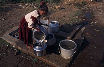 INDIA, Orissa, Gopalpur-on-Sea, Young girl fetching water from stand pipe.