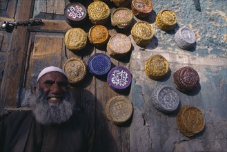 PAKISTAN, Baluchistan, Quetta  , Vendor with display of muslim caps for sale.