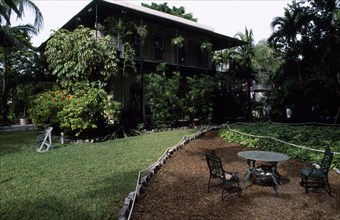 USA, Florida, Key West , "Hemmingway’s home, exterior and garden with iron table and cats asleep on