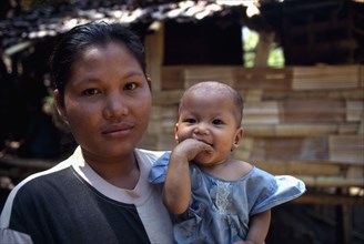 THAILAND, North, Mae Sai Area, Portrait of Karen refugee mother holding child