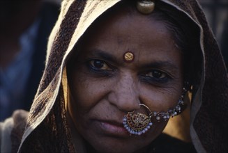 INDIA, Rajasthan, Portrait of woman wearing nose to ear jewellery.