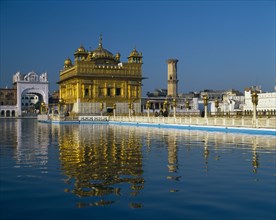 INDIA, Punjab, Amritsar, The Golden Temple with reflection in lake in foreground.