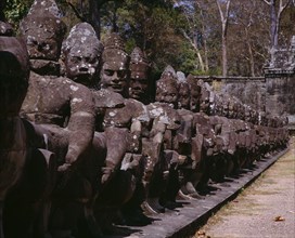 CAMBODIA, Angkor, Angkor Thom.  Close up of ancient stone figures lining causeway leading to
