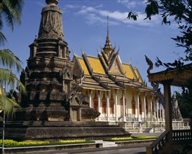 CAMBODIA, Phnom Penh, Silver Pagoda.  Exterior with ornate golden roof with spire and stone